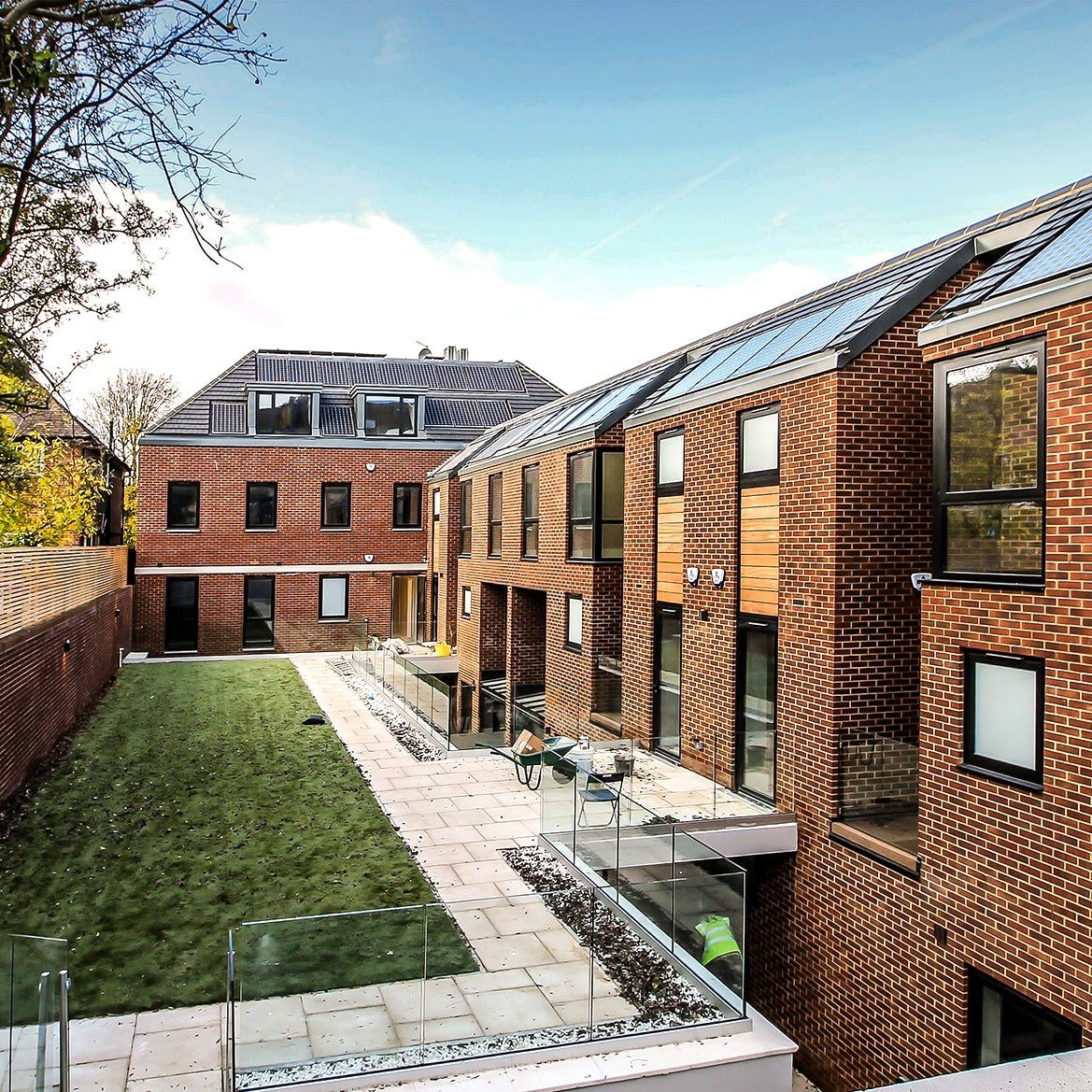 Large red brick L-shape building Hodford Road with many black-frame windows showing grass courtyard and basement