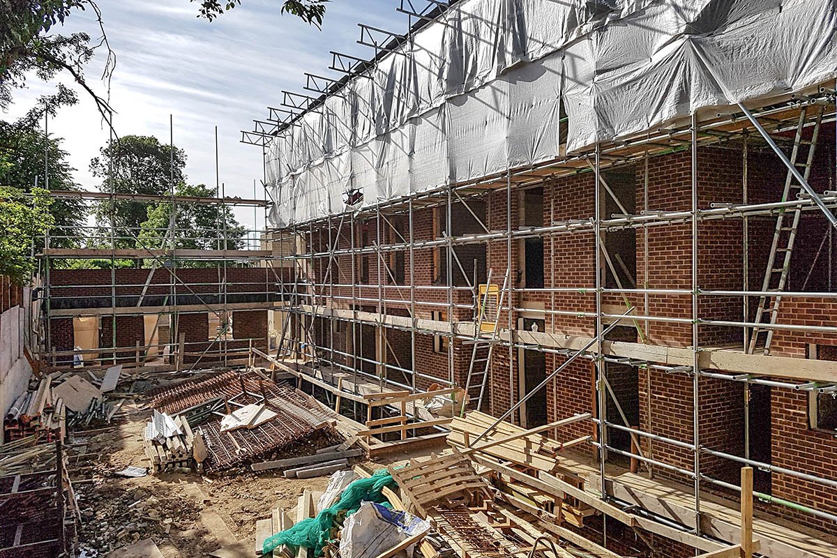 large L-shape red brick building Hodford Road under construction multi-storey scaffolding and tin hat roof