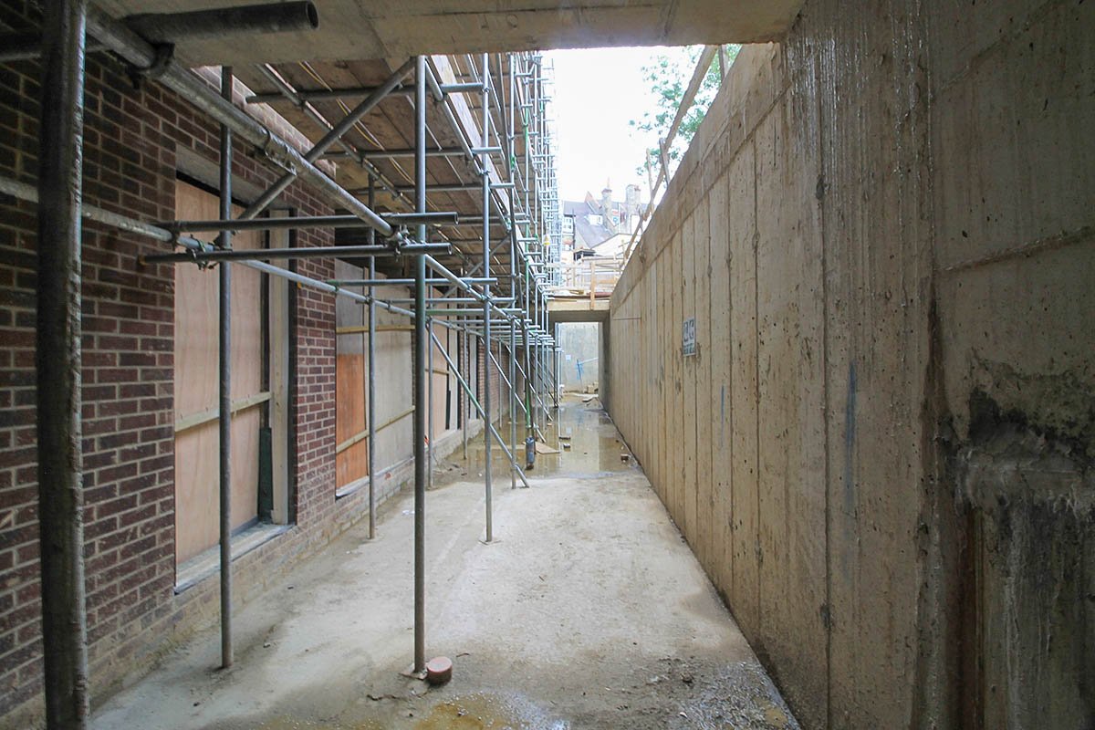 external basement corridor lightwell Hodford Road in-situ concrete and brick walls with scaffolding