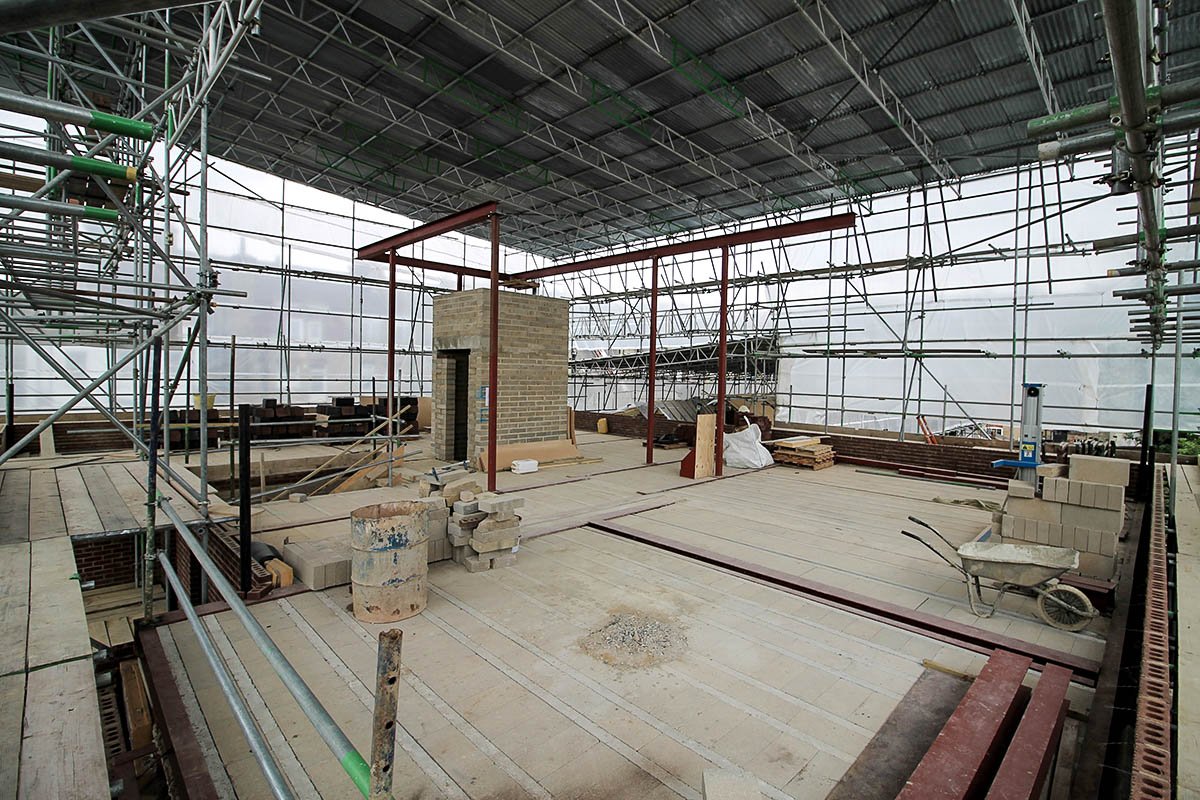 Hodford Road large scaffold tin roof with scaffold sheet on building under construction showing beam and block, steel beams and columns and lift shaft