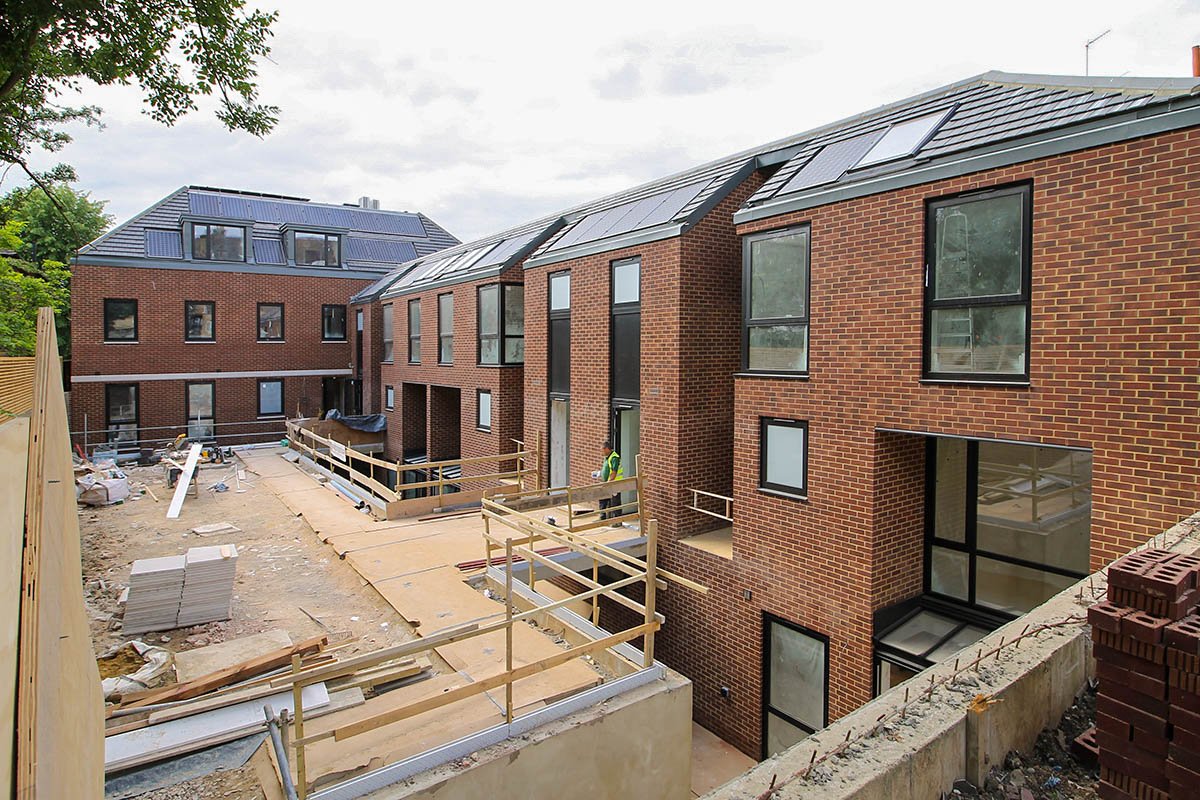 large red brick L-shaped building Hodford Road with four storeys and basement showing windows and solar panels