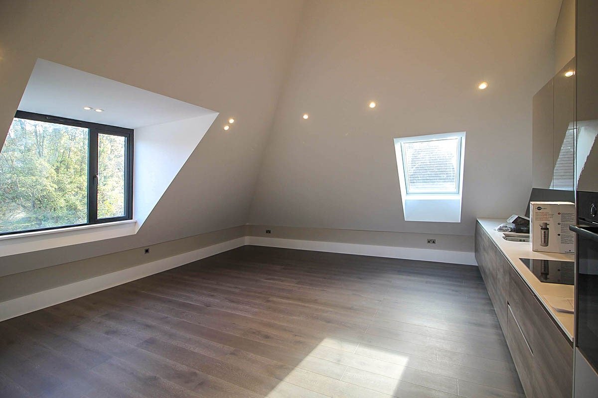 High vaulted kitchen room Hodford Road with dormer windows and grey walls, timber kitchen panelling and LED spotlights