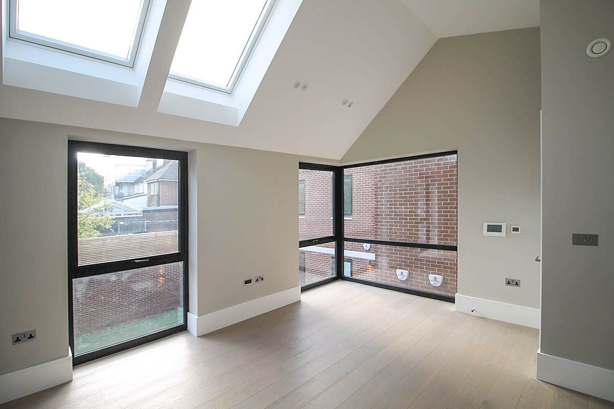 vaulted ceiling grey walled room Hodford Road with white ceiling and 2 skylights, with corner window